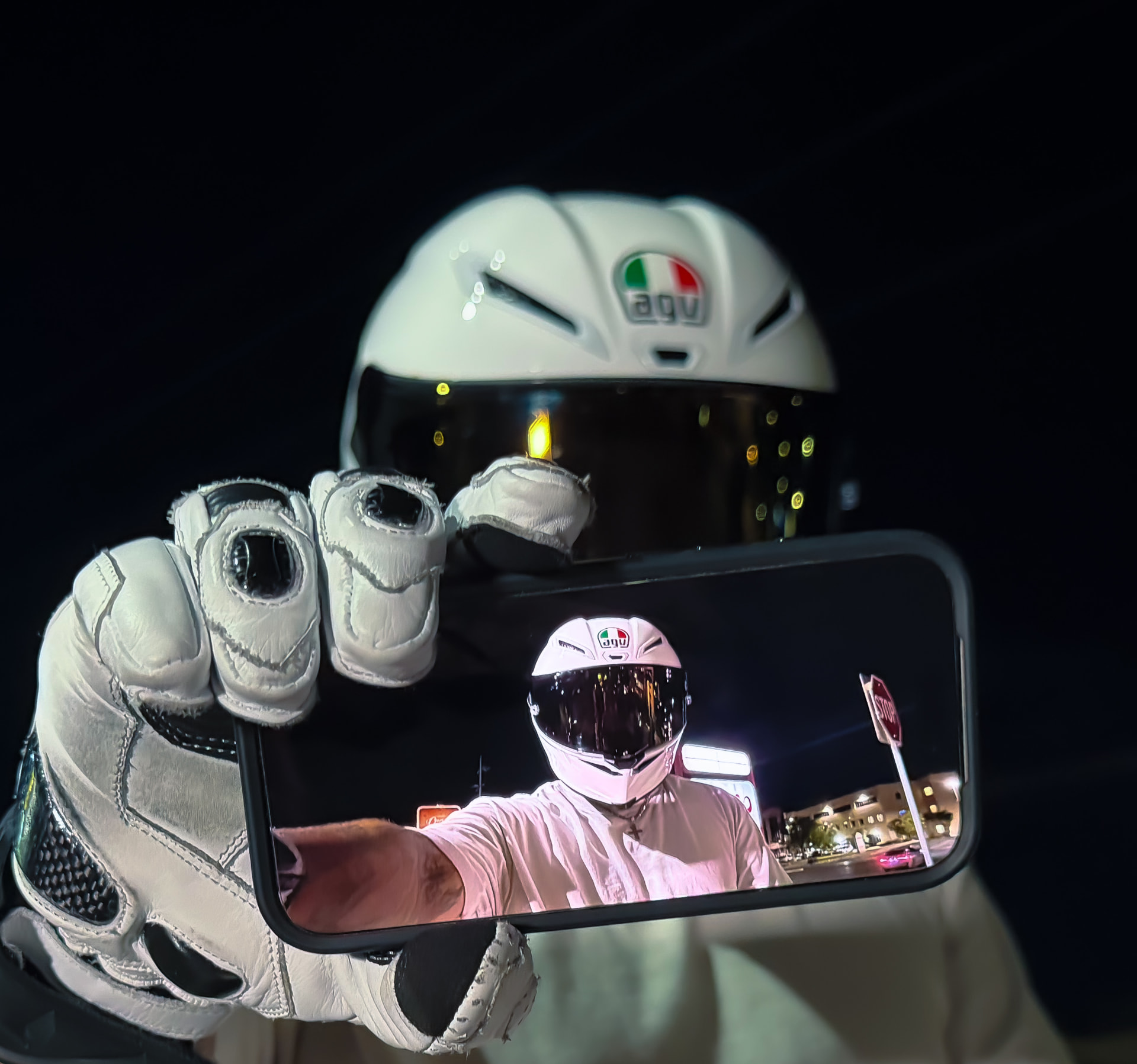 Rider in a white helmet taking a mirror photo at night