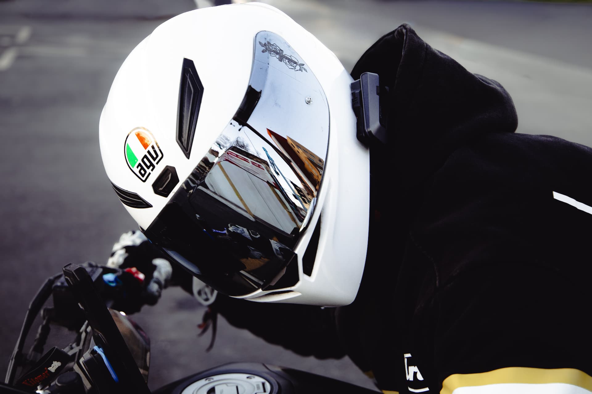 Close-up of a white AGV helmet reflecting the street